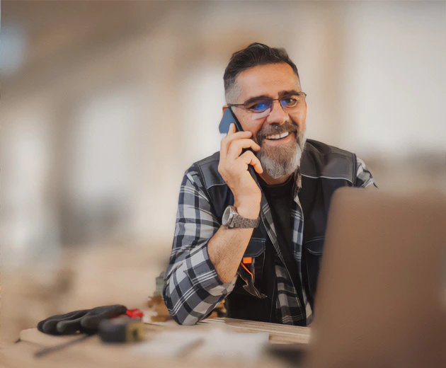 Business owner with dark hair, smiling on the phone